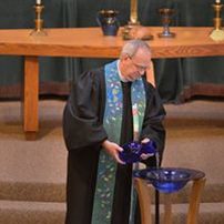 pastor at baptismal font